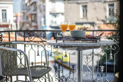 two glasses of beer sitting on a table on a balcony at Ancient Agora Apartments in Athens