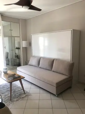 a living room with a couch and a table at Stefanias sunny Acropolis Studio on Drakou pedestrian in Athens
