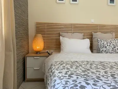 a bedroom with a bed and a lamp on a nightstand at Flight Apartments Airport by Airstay in Spáta