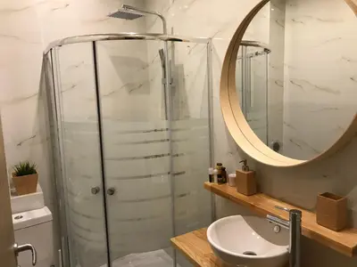 a bathroom with a shower and a sink and a mirror at Flight Apartments Airport by Airstay in Spáta