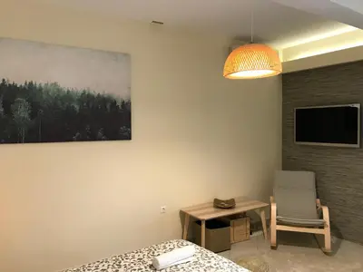 a bedroom with a bed and a chair and a tv at Flight Apartments Airport by Airstay in Spáta