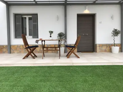 a patio with a table and two chairs and grass at Flight Apartments Airport by Airstay in Spáta