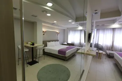 a hotel room with a bed and a couch at Aiolos Apartments Suites Ermou 64 Monastiraki Plaka 2nd Floor in Athens