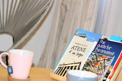 a table with two books and a cup and a mug at Aiolos Apartments Suites Ermou 64 Monastiraki Plaka 2nd Floor in Athens