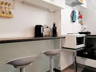 a kitchen with two stools and a microwave on a counter at Athens Pangrati modern apt 10min to metro in Athens