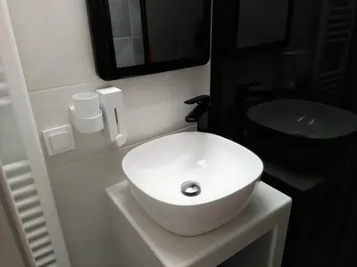 a bathroom with a white sink and a black counter at Athens Pangrati modern apt 10min to metro in Athens
