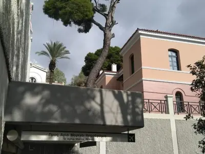 a building with a palm tree in the foreground at Athens Pangrati modern apt 10min to metro in Athens