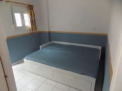 a small bedroom with a bed with a blue wall at George's Apartment in ''Pedion Areos'' area in Athens