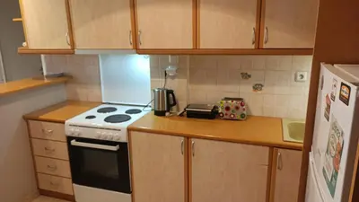 a small kitchen with a stove and a refrigerator at George's Apartment in ''Pedion Areos'' area in Athens