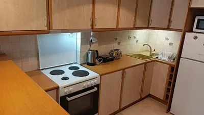 a small kitchen with a stove and a refrigerator at George's Apartment in ''Pedion Areos'' area in Athens