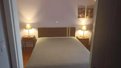 a bedroom with a bed and two lamps on two tables at George's Apartment in ''Pedion Areos'' area in Athens