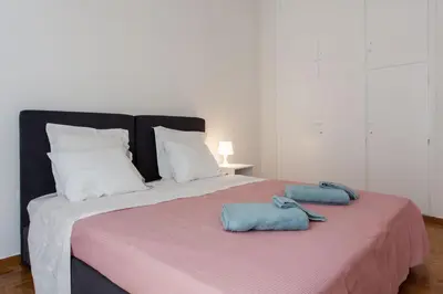 a large bed with two towels on top of it at 2 bdrm apt for up to 6 guests next to Acropolis museum in Athens