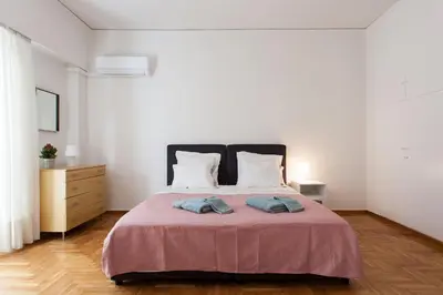 a bedroom with a large bed with two pillows at 2 bdrm apt for up to 6 guests next to Acropolis museum in Athens