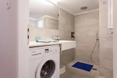 a white washing machine in a bathroom with a shower at 2 bdrm apt for up to 6 guests next to Acropolis museum in Athens