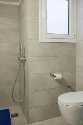 a bathroom with a shower with a toilet and a window at 2 bdrm apt for up to 6 guests next to Acropolis museum in Athens