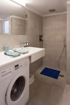 a bathroom with a washing machine and a sink at 2 bdrm apt for up to 6 guests next to Acropolis museum in Athens