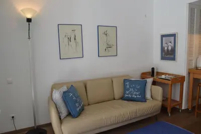 a living room with a couch and two pictures on the wall at Vouliagmeni seaside flat in Athens