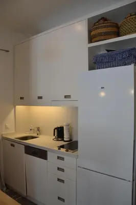 a kitchen with white cabinets and a sink at Vouliagmeni seaside flat in Athens