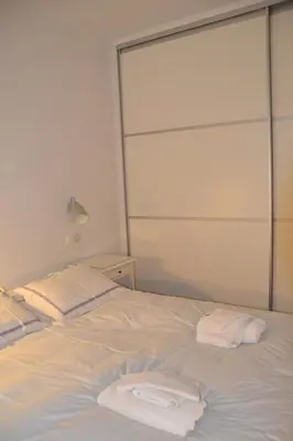 a white bed with two white towels on it at Vouliagmeni seaside flat in Athens