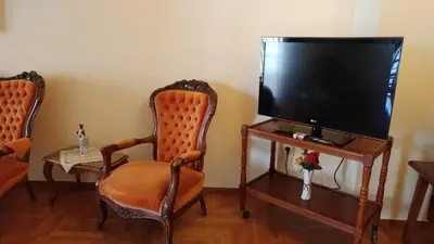 a living room with two chairs and a flat screen tv at Proteus Apartment in Athens