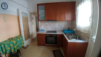 a small kitchen with wooden cabinets and a sink at Proteus Apartment in Athens