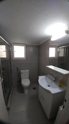 a bathroom with a white toilet and a sink at Proteus Apartment in Athens