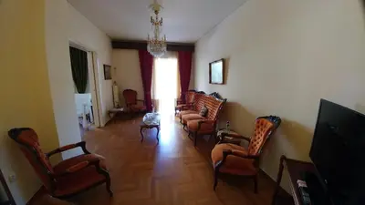 a living room with chairs and a chandelier at Proteus Apartment in Athens