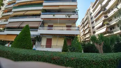 a tall apartment building with plants in front of it at Proteus Apartment in Athens