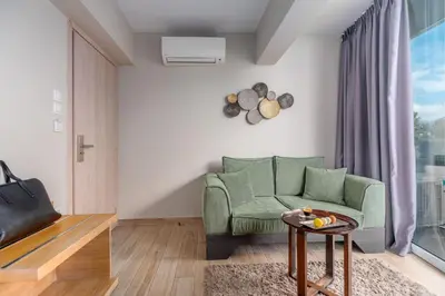a living room with a green couch and a table at Maison 66, Riviera Hotels in Athens