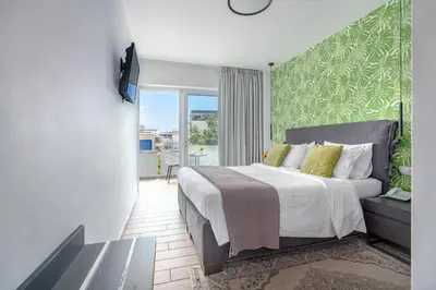 a bedroom with a large bed and a balcony at Maison 66, Riviera Hotels in Athens