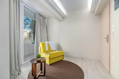 a living room with a yellow chair and a window at Maison 66, Riviera Hotels in Athens