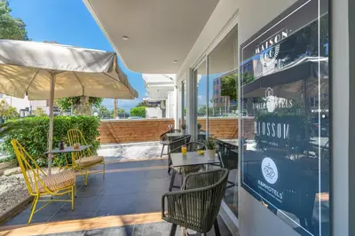 a restaurant with chairs and tables and an umbrella at Maison 66, Riviera Hotels in Athens