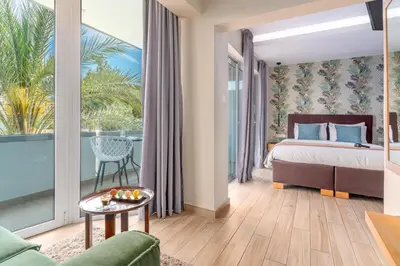 a hotel room with a bed and a balcony at Maison 66, Riviera Hotels in Athens