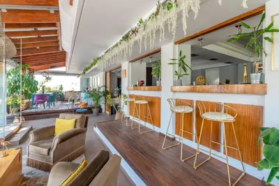 a restaurant with chairs and a bar with plants at Maison 66, Riviera Hotels in Athens
