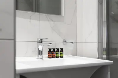 a bathroom with a sink with three bottles on it at Syntagma Spotlight Residence in Athens