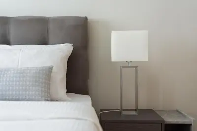 a lamp on a night stand next to a bed at Syntagma Spotlight Residence in Athens