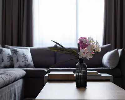 a vase with flowers on a table in a living room at Syntagma Spotlight Residence in Athens