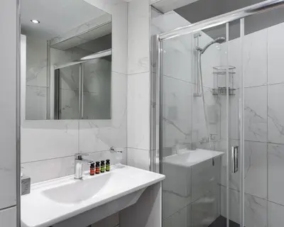 a white bathroom with a sink and a shower at Syntagma Spotlight Residence in Athens