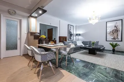 a living room with a table and chairs at Piraeus Port Marouso in Piraeus