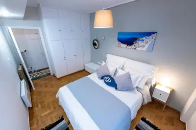 a bedroom with a large white bed with blue pillows at Piraeus Port Marouso in Piraeus