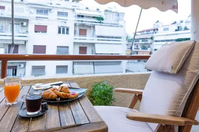 a table with a plate of food and a glass of orange juice at Piraeus Port Marouso in Piraeus