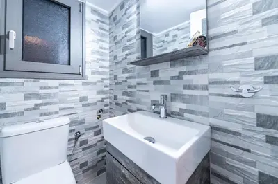 a bathroom with a white sink and a toilet at Piraeus Port Marouso in Piraeus