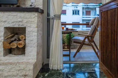 a living room with a stone fireplace and a chair at Piraeus Port Marouso in Piraeus