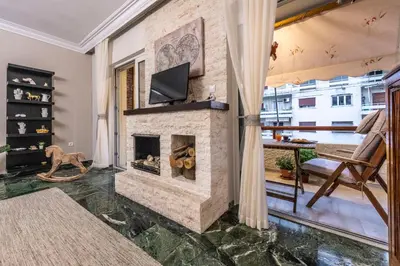 a living room with a stone fireplace with a tv at Piraeus Port Marouso in Piraeus