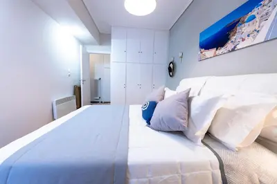 a bedroom with a large white bed with pillows at Piraeus Port Marouso in Piraeus