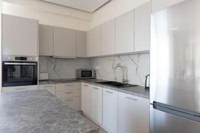 a kitchen with white cabinets and a stainless steel refrigerator at Luxurious 3-Bedroom Seaside Retreat Fully Renovated in 2025 in Athens