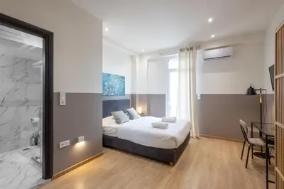 a bedroom with a king sized bed and a table at Luxurious 3-Bedroom Seaside Retreat Fully Renovated in 2025 in Athens