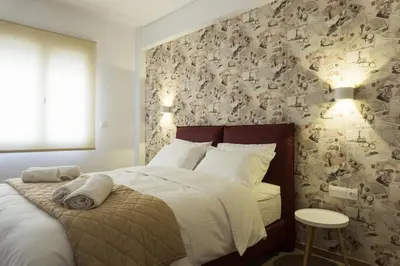a bedroom with a bed and a wall covered in photographs at Comfort Zone Apartment in the heart of Athens in Athens