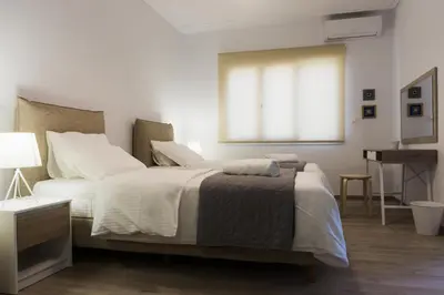 a bedroom with a bed and a desk and a window at Comfort Zone Apartment in the heart of Athens in Athens