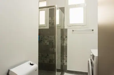 a bathroom with a shower with a glass door at Comfort Zone Apartment in the heart of Athens in Athens